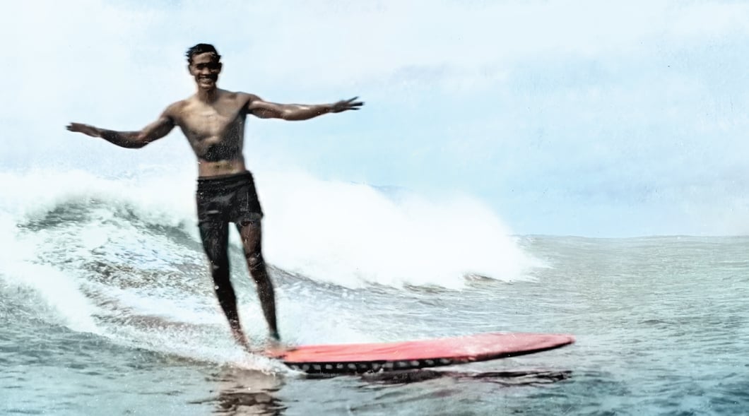 Photo of a surfer smiling while riding a wave