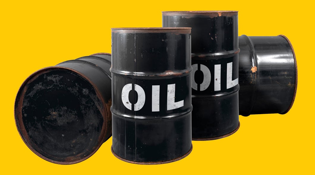 Four black metal oil barrels labeled Oil, two upright and two on their sides